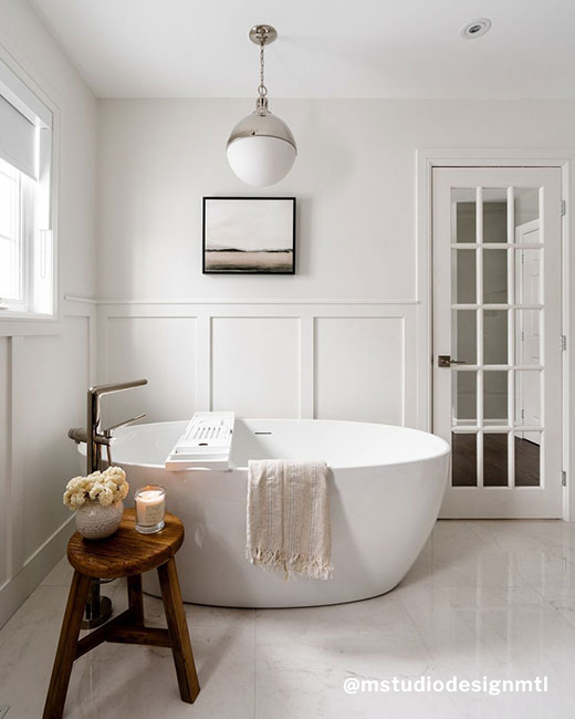 an oval shaped freestanding bathtub in a cozy bathroom setup