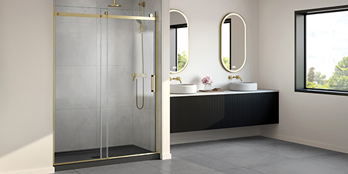 An elegant bathroom displaying high-quality Fleurco sliding shower doors in brushed gold finishes and a sleek vanity with double sinks & two oblong LED mirrors