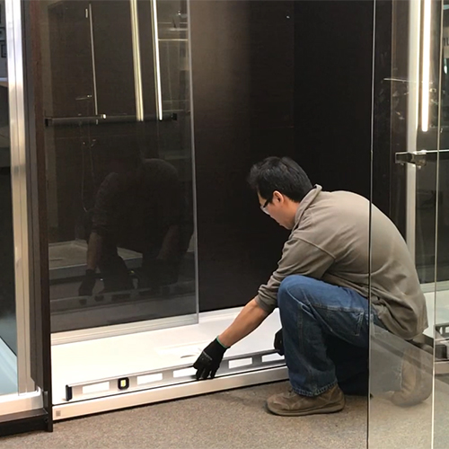 fleurco installer placing a spirit level at the curb of the shower opening